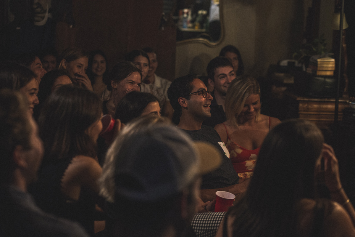 Crowd laughing during Live at the Barbershop NYC inside an East Village barbershop