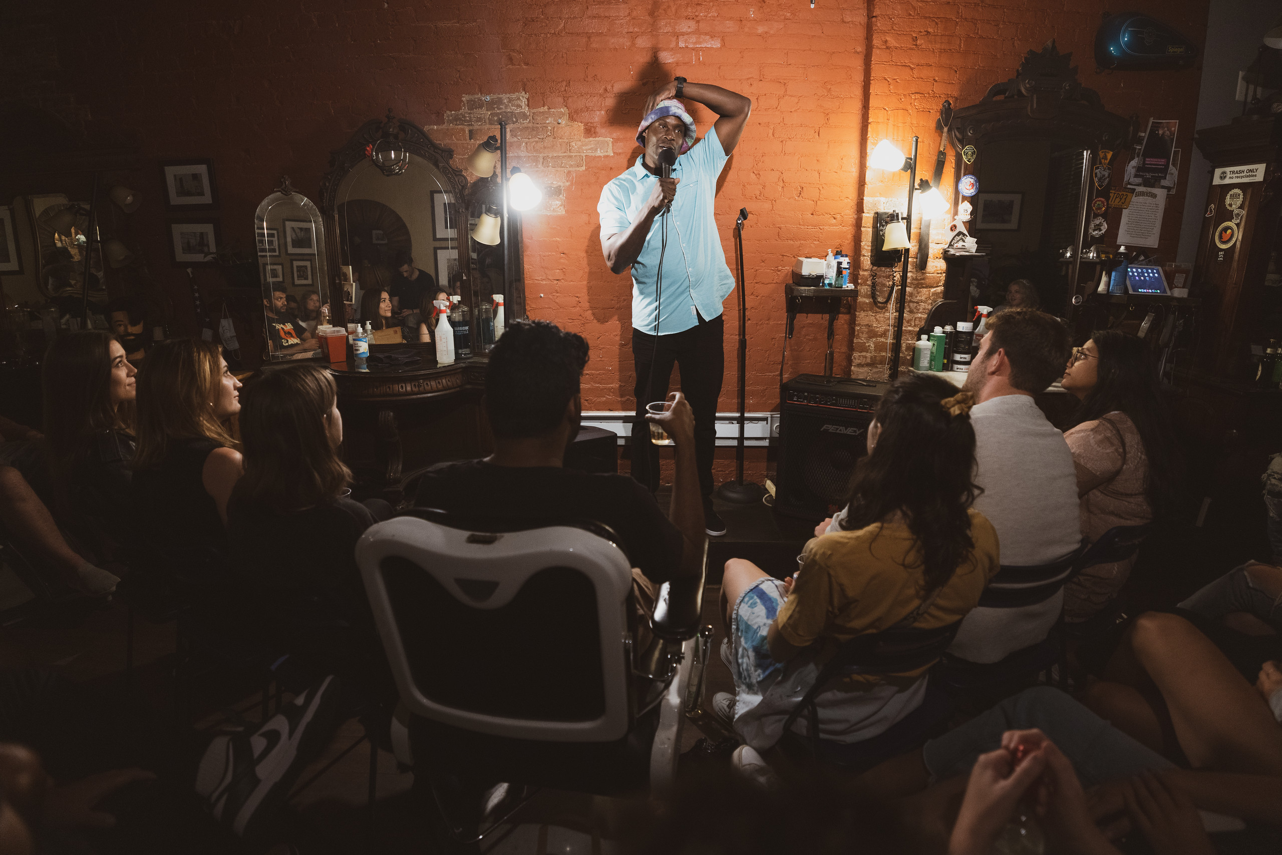 Stand up comedian performing at Live at the Barbershop NYC in a real barbershop